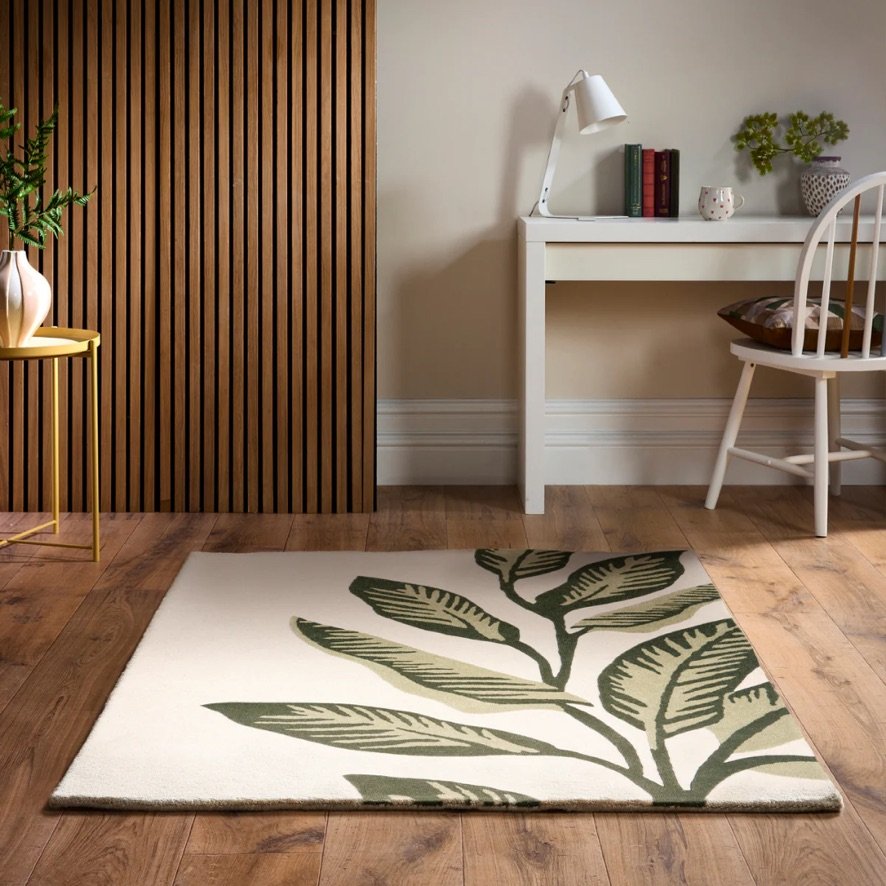 Origins Paradise Leaf rug with oversized green leaf motif and hand‑carved wool texture on an ivory background.