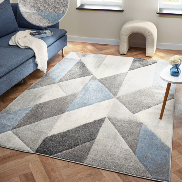Orbit Alto rug featuring layered blue shades and a smooth modern texture, shown laid flat in a bright contemporary room.