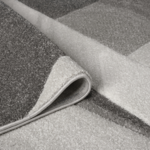 Orbit Lumen Grey rug with subtle tonal shading and a clean textured finish, styled on a minimalist floor surface.