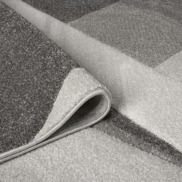 Orbit Lumen Grey rug with subtle tonal shading and a clean textured finish, styled on a minimalist floor surface.