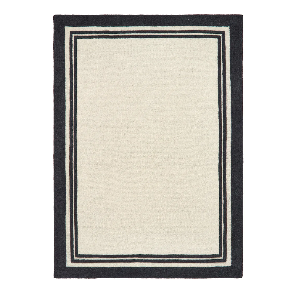 Piper Monochrome rug featuring a bold black border around a soft cream wool centre.
