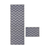 Grey flatweave rug with chevron design on white background.